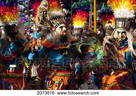 Stock Photograph - Tobas Dancers Wearing Elaborate Masks, Feather Headdresses And Costumes In The Procession Of The Carnaval De Oruro, Oruro, Bolivia. Fotosearch