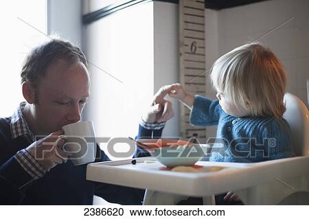 Toddler and uncle having cereal for breakfast in the kitchen; Toronto, Ontario, Canada View Large Photo Image Stock Image - Toddler and uncle having cereal for breakfast in the kitchen; Toronto, Ontario, Canada. Fotosearch