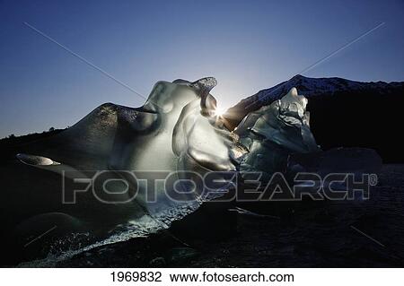 Stock Image - Tongass Forest, Alaska, Recently Calved From The Terminus Of Mendenhall Glacier In Mendenhall Lake, An Iceberg Transmits The Light From The Setting Sun.. Fotosearch