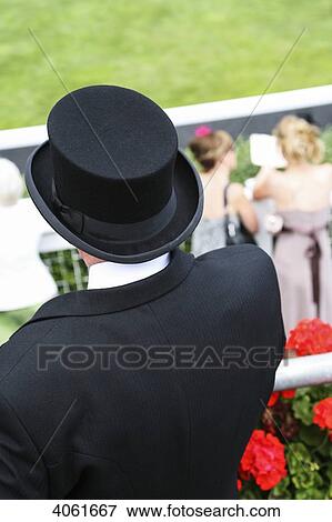 Stock Photo - Top hat and dressed up at parade ring during Royal Ascot horse racing meeting; Berkshire, England. Fotosearch