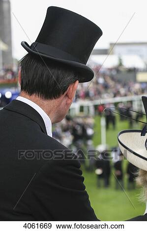 Stock Photo - Top hat and dressed up at parade ring during Royal Ascot horse racing meeting; Berkshire, England. Fotosearch