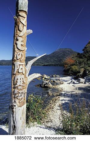 Stock Image - Totem Pole And Landscape Around The Edge Of Lake Akan. Fotosearch