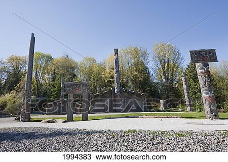 Stock Image - Totem Poles And Haida Houses On The Grounds Of The Museum Of Anthropology At The University Of British Columbia, Vancouver, British Columbia, Canada. Fotosearch