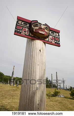 Stock Image - Totem Poles In The Namgis Burial Grounds; Alert Bay, Cormorant Island, British Columbia, Canada. Fotosearch
