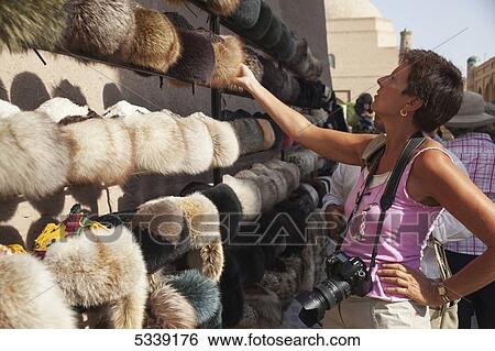 Stock Photograph - Tourist at hat stall, inside Ichan Kala Old City; Khiva, Khwarezm, Uzbekistan. Fotosearch