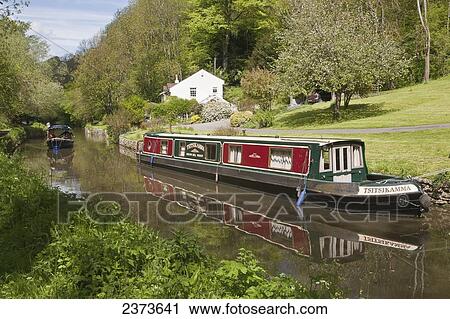 Tourist boat passing narrowboat moored on Kennet and Avon Canal; Wiltshire, England View Large Photo Image Stock Image - Tourist boat passing narrowboat moored on Kennet and Avon Canal; Wiltshire, England. Fotosearch