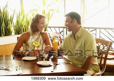 Stock Photo - Tourist Couple At An Island Style Bar Enjoying Cocktails. Fotosearch