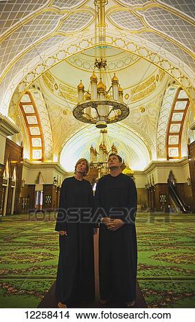 Picture - Tourist couple inside Sultan Omar Ali Saifuddien Mosque; Bandar Seri Begawan, Brunei. Fotosearch