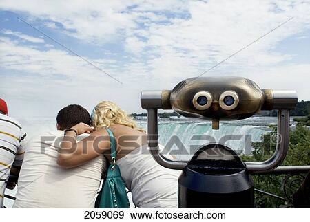 Stock Photo - Tourist Couple Standing Over The Railing On The Canadian Side Of Niagara Falls, Ontario, Canada. Fotosearch