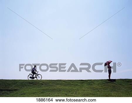 Picture - Tourist Holding Parasol And Man On Bicycle. Fotosearch