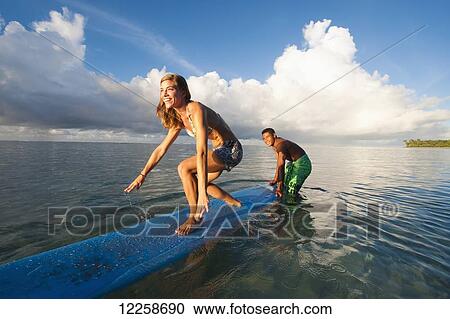 Stock Image - Tourist learning to surf; Samoa. Fotosearch