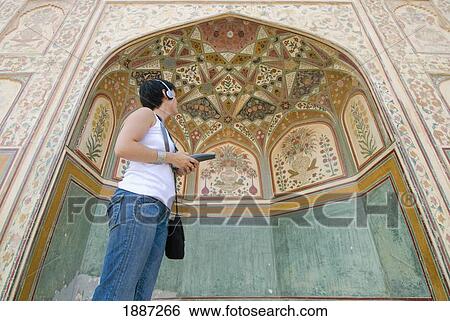 Stock Photograph - Tourist Listening To Audio Guide In Amber Fort, Low Angle View. Fotosearch