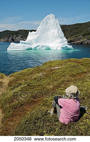 Stock Photo - Tourist Looking At An Iceberg Floating In Trinity Bay Off The Bonavista Peninsula, Eastern Newfoundland.. Fotosearch