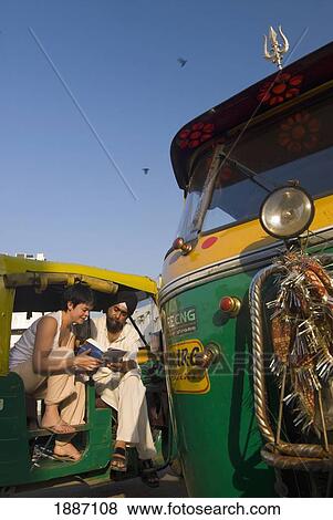 Tourist Looking At Guide Book With Sikh Rickshaw Driver View Large Photo Image Stock Photo - Tourist Looking At Guide Book With Sikh Rickshaw Driver. Fotosearch