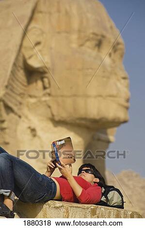 Stock Photo - Tourist Lying On Back And Reading Guidebook, Great Sphinx In Background. Fotosearch