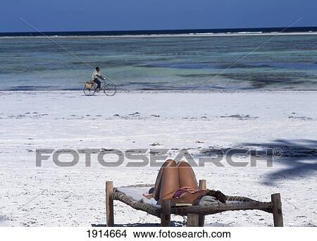 Picture - Tourist On Sun Lounger And Cyclist. Fotosearch