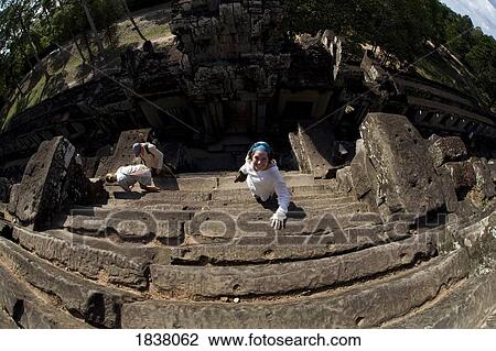 Stock Image - Tourist On Temple Stairs In Ancient City Of Angkor; Angkor Wat, Siem Reap, Cambodia. Fotosearch