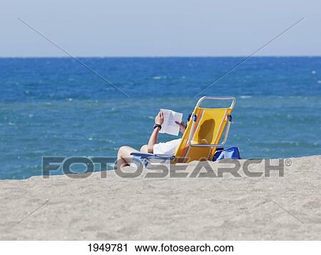 Tourist Reading On A Chair On The Beach On Cala De Mijas; Fuengirola Malaga Province Costa Del Sol Spain View Large Photo Image Stock Image - Tourist Reading On A Chair On The Beach On Cala De Mijas; Fuengirola Malaga Province Costa Del Sol Spain. Fotosearch