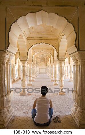 Stock Image - Tourist Sitting In Columned Hallway, Amber Fort. Fotosearch