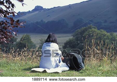 Picture - Tourist Sitting In Countryside Admiring View. Fotosearch