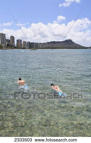 Stock Image - Tourist snorkelling off the coast; Honolulu, Oahu, Hawaii, United States of America. Fotosearch