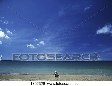 Stock Photo - Tourist Sun-Bathing On Idyllic Sandy Beach. Fotosearch