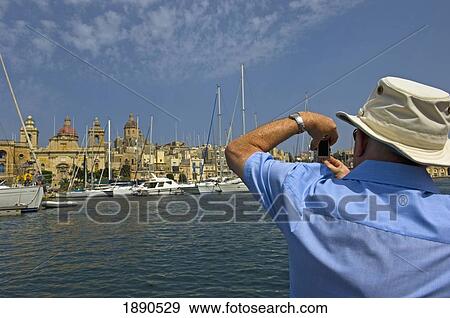 Stock Photo - Tourist Taking Photograph Of Vittoriosa. Fotosearch