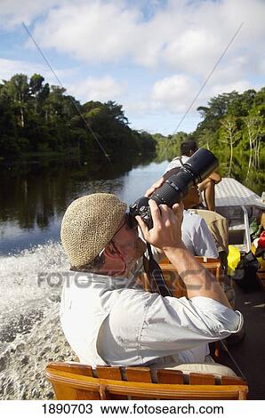 Tourist Taking Photographs Sitting In Boat On River; Peru View Large Photo Image Stock Image - Tourist Taking Photographs Sitting In Boat On River; Peru. Fotosearch