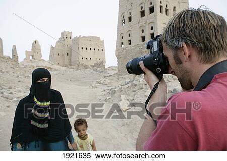 Stock Photography - Tourist Taking Photos Of Locals. Fotosearch