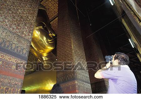 Stock Photography - Tourist Videoing Huge Reclining Buddha Statue At Wat Po Temple. Fotosearch