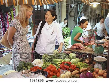 Stock Photograph - Tourist With Cook At Market Metropole Hotel Cookery School; Hanoi Vietnam. Fotosearch