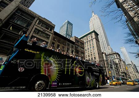 Stock Photo - Touristic Bus Passing In Front Of The Empire State Building, Manhattan, New York, Usa. Fotosearch