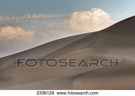 Tourists And Camels Climbing The Slopes Of Singing Sand Mountain; Jiuquan, Gansu, China View Large Photo Image Stock Photo - Tourists And Camels Climbing The Slopes Of Singing Sand Mountain; Jiuquan, Gansu, China. Fotosearch