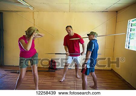 Stock Photo - Tourists being silly and playing with spears at the floating village; Bandar Seri Begawan, Brunei. Fotosearch