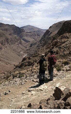 Stock Photograph - Tourists / Couple Walking / Trekking, High Atlas Mountains, Todra Gorge, Morocco. Fotosearch