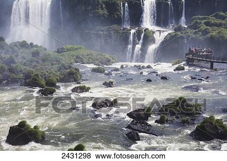 Tourists crowd on to concrete walkways above the waterfalls at Iguacu National Park; Brazil View Large Photo Image Stock Photo - Tourists crowd on to concrete walkways above the waterfalls at Iguacu National Park; Brazil. Fotosearch