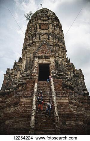 Tourists descend the steps of a ruined temple in the ancient city of Ayutthaya in central Thailand; Ayutthaya, Thailand View Large Photo Image Picture - Tourists descend the steps of a ruined temple in the ancient city of Ayutthaya in central Thailand; Ayutthaya, Thailand. Fotosearch