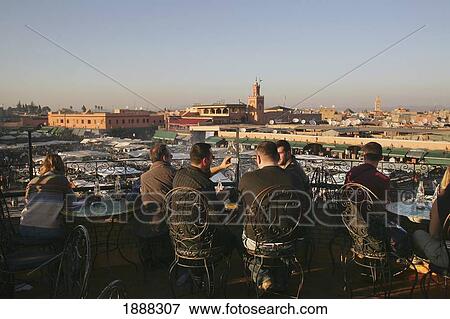 Stock Photo - Tourists Drinking Tea On The Balcony Of Cafe Overlooking Djemaa El Fna Night Market.. Fotosearch