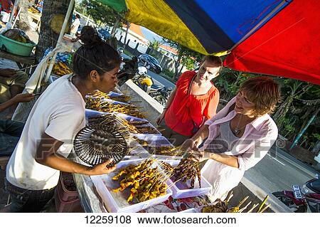 Stock Photo - Tourists eating at the local food stalls; Dili, Timor-Leste. Fotosearch