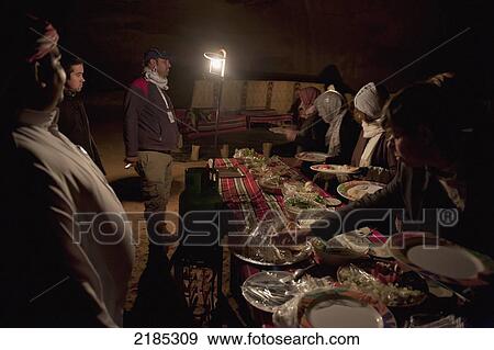 Stock Photo - Tourists Enjoying A Traditional Zarb Dinner At The Captain's Eco Desert Camp, Wadi Rum, Jordan, Middle East. Fotosearch