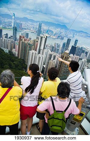Tourists Enjoying The View From Victoria Peak Over The Skyline Of High Rise Buildings Of Victoria Harbour, Hong Kong Island And Kowloon; Victoria Peak, Hong Kong Island, China, Asia. View Large Photo Image Stock Photo - Tourists Enjoying The View From Victoria Peak Over The Skyline Of High Rise Buildings Of Victoria Harbour, Hong Kong Island And Kowloon; Victoria Peak, Hong Kong Island, China, Asia.. Fotosearch