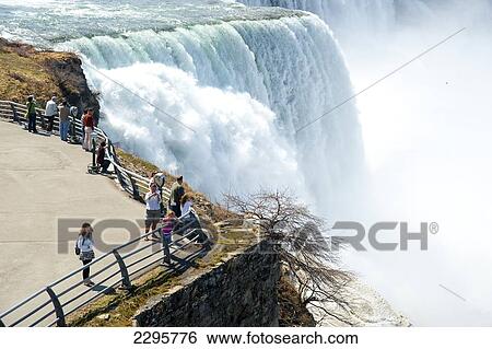 Stock Photograph - Tourists Enjoying The View Of Niagara Falls, Ontario And New York Border, Canada And United States Of America. Fotosearch
