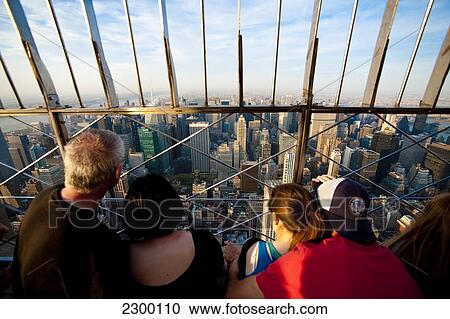 Stock Image - Tourists Enjoying The Views Of Manhattan From The Top Of The Empire State Building, New York, Usa. Fotosearch