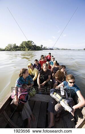 Stock Photograph - Tourists In Wooden Boat, Laos. Fotosearch