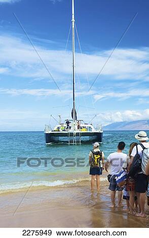 Stock Photo - Tourists lining up on the shore waiting for a boat; Hawaii, United States of America. Fotosearch
