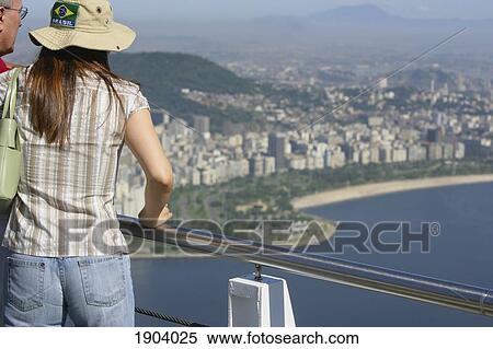 Tourists Looking At View From Sugar Loaf Mountain, Rio De Janeiro, Brazil View Large Photo Image Stock Photography - Tourists Looking At View From Sugar Loaf Mountain, Rio De Janeiro, Brazil. Fotosearch