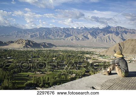 Stock Photograph - Tourists looking out from the Shanti (Peace) Stupa in Changspa looking over Leh. Leh was the capital of the Himalayan kingdom of Ladakh, now the Leh District in the state of Jammu and Kashmir, India. Leh is at an altitude of 3, 500 meters (11, 483 ft).. Fotosearch