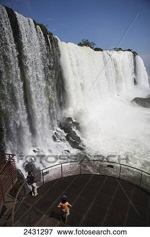 Tourists on a lookout of the waterfalls at Iguacu National Park; Brazil View Large Photo Image Stock Photo - Tourists on a lookout of the waterfalls at Iguacu National Park; Brazil. Fotosearch