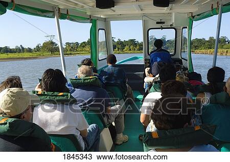 Stock Image - Tourists On A River Boat Cruise; Tortuguaro, Limon, Costa Rica. Fotosearch