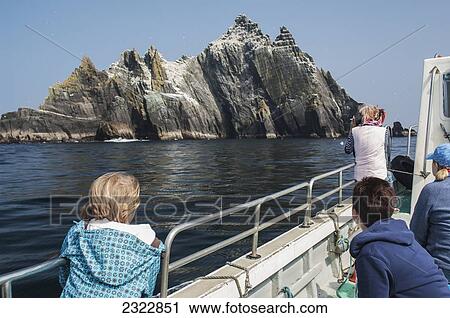 Stock Image - Tourists on boat close to Little Skellig; Skellig Islands, County Kerry, Ireland, UK. Fotosearch